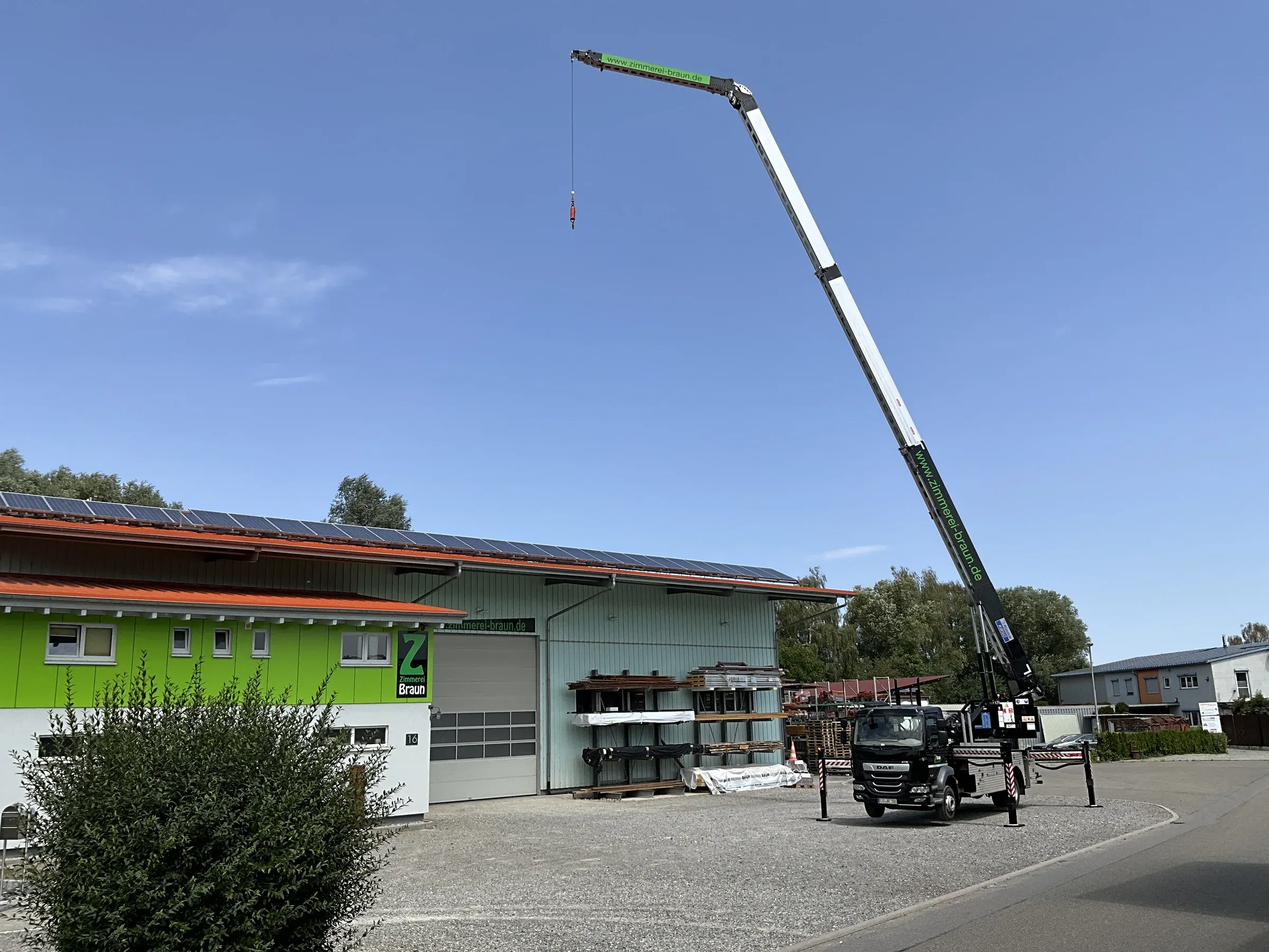 Autokran der Zimmerei Braun mit vollständig ausgefahrenem Ausleger
